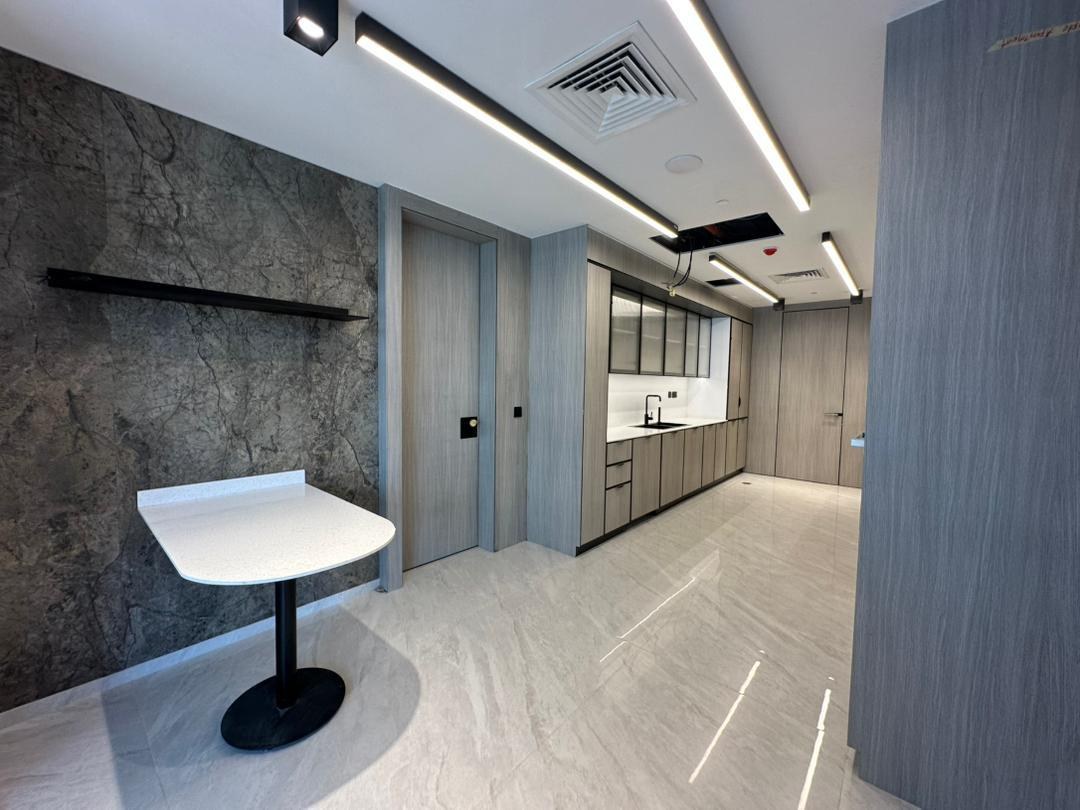 Curved Staron table against the marble-effect feature wall